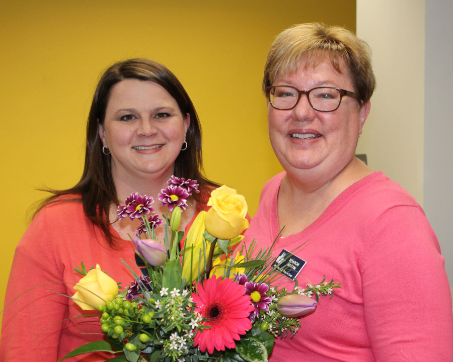 Amy DeVault (left) received a bouquet of flowers and the news that she had been named the first winner of the Friend of KSPA Award. Board member Sharon Martin of Wichita East presented the bouquet.