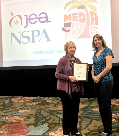 Mary Patrick, left, of Maize South Middle School accepts the Pioneer Award from NSPA board member Jeanne Acton at the Nov. 14 adviser awards lunch at the Orlando NSPA/JEA national convention.