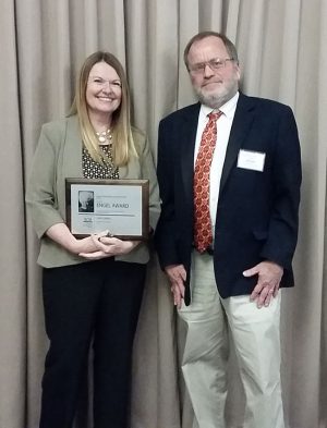 Andover Central publications adviser Julie Calabro accepts the Jackie Engel Award for 2016 from Mike Swan of Kansas Collegiate Media and Butler Community College