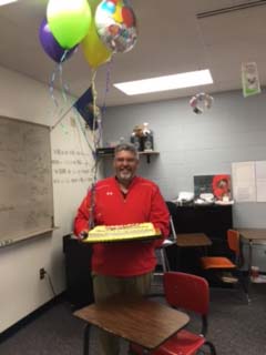 Dan Loving of Maize High School accepts balloons and a cake April 6 in recognition of winning the Sunflower Award.