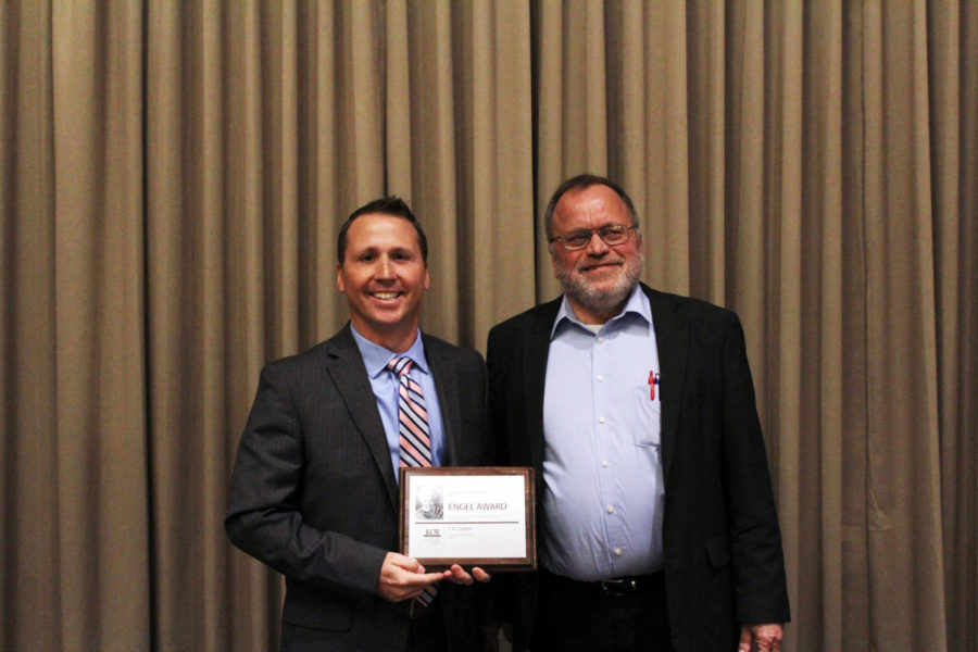 Salina Central adviser J.D. Garber (left) poses with Michael Swan, Kansas Collegian Media Jackie Engel Award Coordinator (right). Garber received the Jackie Engel Award at the KCM Awards Conference on April 9. Photo by Nadine Armstrong.