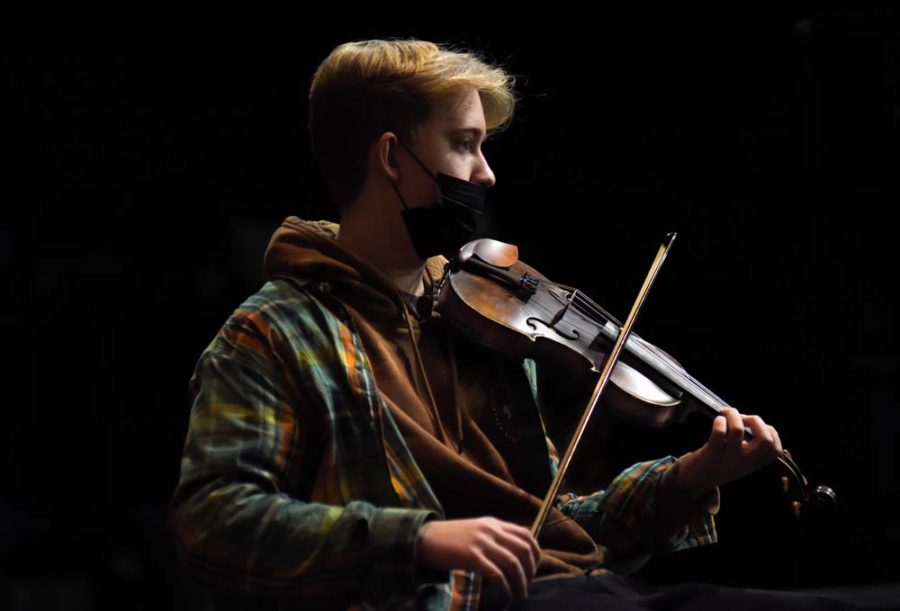 Lost in the music, junior Matthew Sutton rehearses songs with the orchestra before their concert. The Orchestra and chior were working together to perform the song gloria. "my favorite song was probably Concert Concerto, it was an exciting song to play alongside the chior".